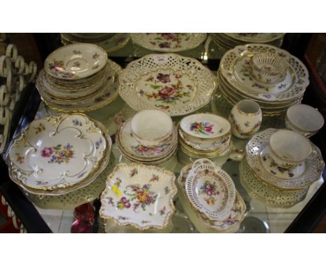 A collection of Dresden porcelain including pierced plates, dishes, tea cups and saucers