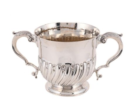 
	
		A VICTORIAN SILVER TWIN HANDLED CUP
		WAKELY &amp; WHEELER, LONDON 1887 
		The half lobed and fluted body with twin leaf