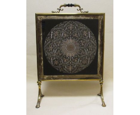 A late 19th century/early 20th century brass and glazed firescreen with later embroidered panels 