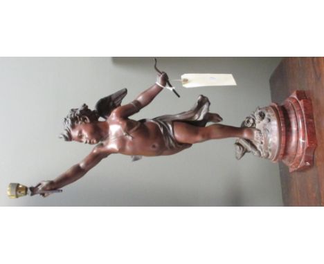 A spelter lamp of a cherub holding a light aloft, on faux marble base, converted for electricity 