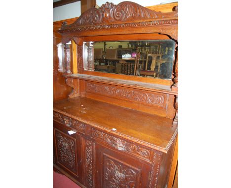 A good late 19th century heavily carved oak mirrorback sideboard, the upper section having integral shelf 