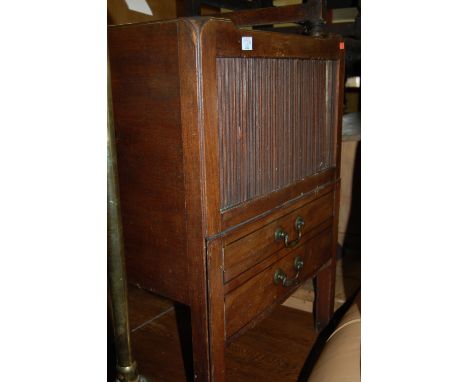 A George III mahogany tambour fronted commode having a pull-out lower compartment
