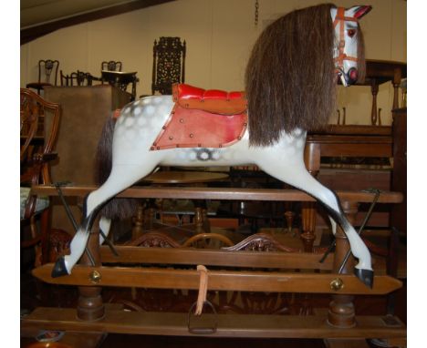 A Victorian style dapple grey rocking horse, having padded seat and raised on stained wood stand, h.120cm