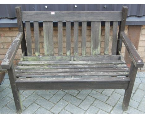 A stained and slatted garden two-seater bench 