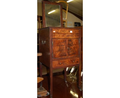 An early 19th century mahogany and rosewood cross banded Gentleman's night stand, having rise and fall mirror over twin cupbo