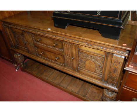 A good quality 17th century style joined and carved oak dresser base, having two central drawers flanked by a recess panel cu