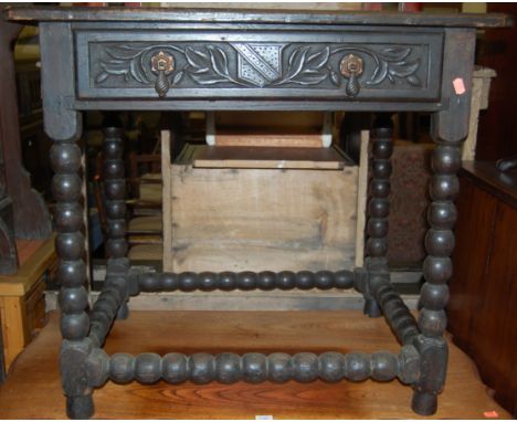 An antique low relief carved oak single drawer side table on bobbin turned supports