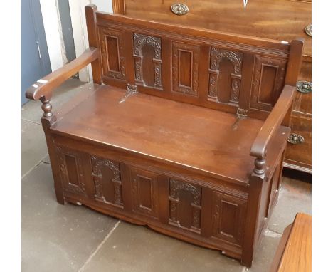 A carved oak monk's bench, width 99cm. 