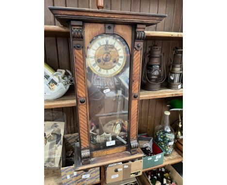 A wall clock with pendulum and key. 