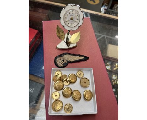 A Kaiser mechanical alarm clock modelled as a flower together with a small tray of military buttons and a sew on patch 