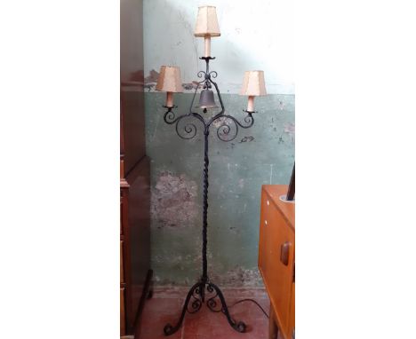 A wrought metal floor lamp with brass bell. 