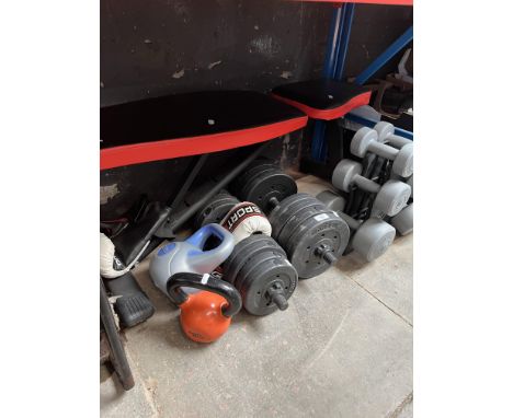 A weightlifting bench together with weights and boxing gloves. 