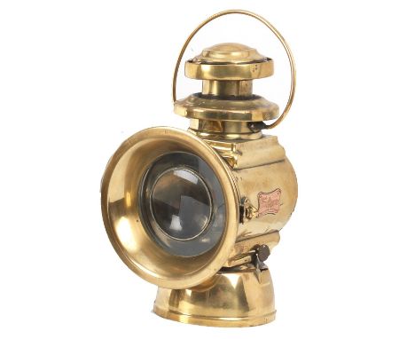 A Lucas No.664 oil-illuminating side-lamp,polished brass body, for left side spade mounting, with 4¾ inch clear lens with 3¼ 