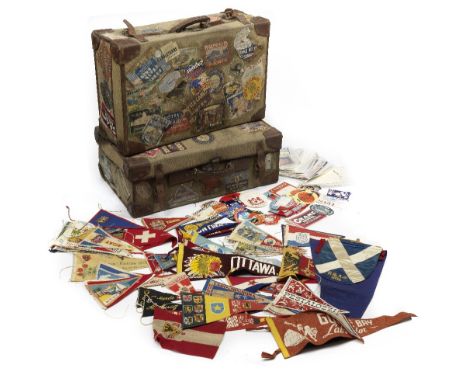 Two suitcases and assorted travel labels and pennants,the two canvas suitcases with leather handles and trim, 70cm wide, worn