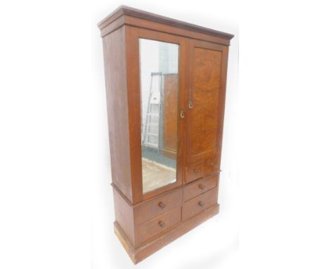 A late Victorian oak and burr elm double wardrobe, with a moulded cornice above a mirrored door, enclosing hanging hooks besi