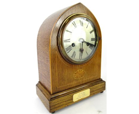 A 20thC oak cased mantel clock, the mitre shaped case on a rectangular base, terminating in orb feet, holding a 12cm diameter