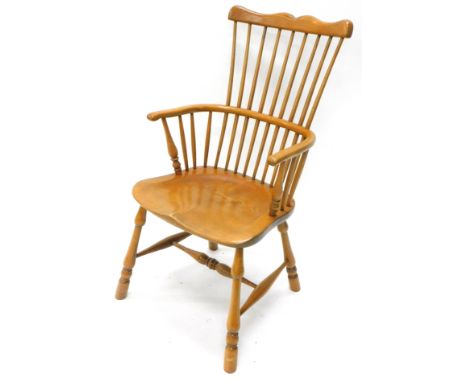 A comb top Windsor chair, with a double vertical spindle back, 'C' shaped arms, shaped saddle seat and turned legs, joined by