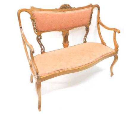 An early 20thC mahogany serpentine salon settee, with overstuffed back and seat, in scroll material, with scroll arms and inv