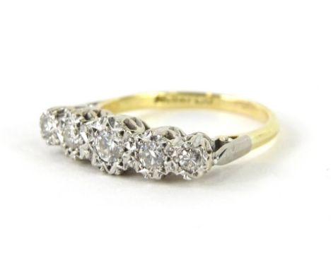 An 18ct gold five stone diamond ring, the five graduated illusion set diamonds, on a part pierced shank in platinum, the larg