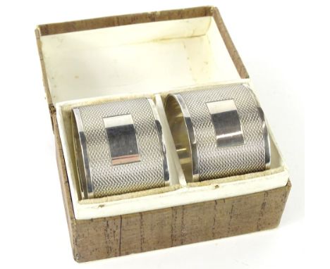 A cased pair of George VI silver napkin rings, each of cylindrical form, partially engine turned, Sheffield 1950, in fitted c