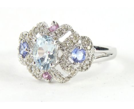 A ladies 9ct white gold dress ring, the pierced top claw set with an oval blue stone and set with further blue and pink stone