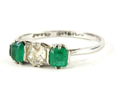 An emerald and diamond three stone ring, with central old cut diamond, measuring 4.8mm x 4.8mm x 2.4mm, approx 0.35cts, flank