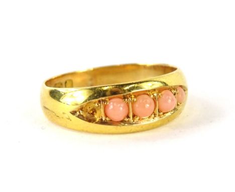 A ladies 18ct gold dress ring, set with four graduated coral stones, size K½, (one small stone missing).