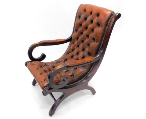 A 20thC mahogany framed scroll library armchair, with brown button back leather to the back and arm pads, on shaped legs, 100