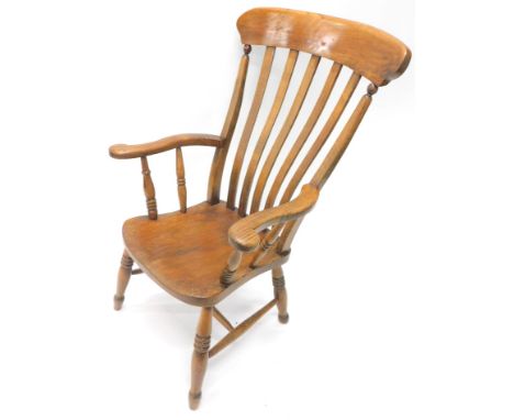 A late 19thC ash and elm grandfather chair, with carved cresting rail, vertical lath back, shaped arms, cylindrical supports 