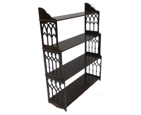 A mahogany wall shelf in Chippendale style, with three graduated tiers and pierced Gothic end supports, 52cm wide.