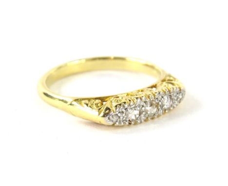 An Art Deco style diamond dress ring, with shaped ring head, set with five tiny old cut diamonds, in platinum setting, with s