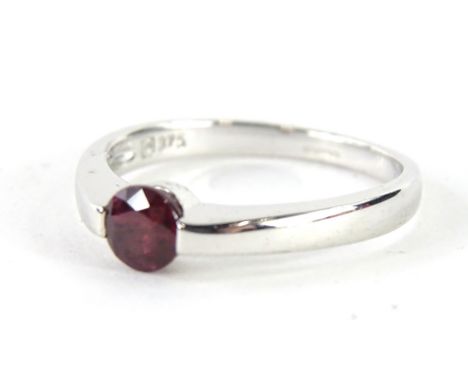 A 9ct white gold solitaire dress ring, set with red stone, on an Art Deco style shank, size O, 3.2g all in.