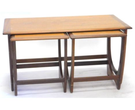 A late 1960's G-Plan teak table unit, of rectangular form, with two removable stools, each with shaped legs, joined by cylind