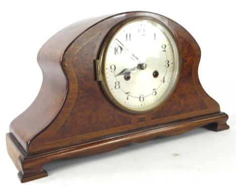 An early 20thC burr walnut and mahogany mantel clock, the shaped case with a wide crossbanding on bracket feet, with a 15cm d