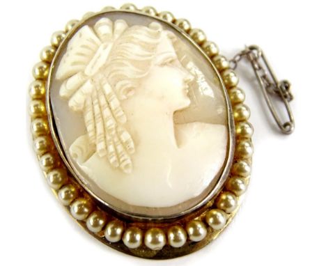 A silver framed shell cameo brooch, the shell cameo of maiden facing dexter, (AF), with a faux pearl surround, 3.5cm x 4.5cm.