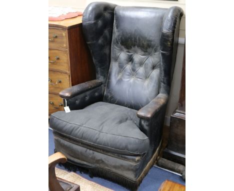 A leather button back wing armchair