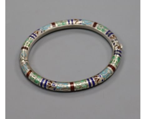 An Egyptianesque white metal and enamel hinged bangle.