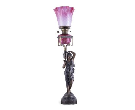 A SPELTER CLASSICAL FEMALE FIGURAL OIL LAMP WITH RUBY GLASS BOWL, modelled as a female figure holding a classical vase and su