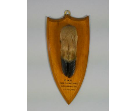 A taxidermy Deer hoof, mounted to a golden oak shield-shaped plaque inscribed: “D &amp; S., Found Shircombe, Killed Lukboroug