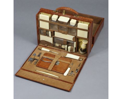 AN ASPREY OF LONDON CROCODILE-SKIN GENT’S TRAVELLING TOILET CASE, with brass twin-lever locks, ivory-mounted fittings, &amp; 