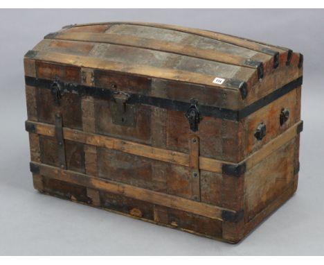A steal-bound wooden ribbed domed-top trunk with a hinged lift-lid, 32” wide x 21” high.