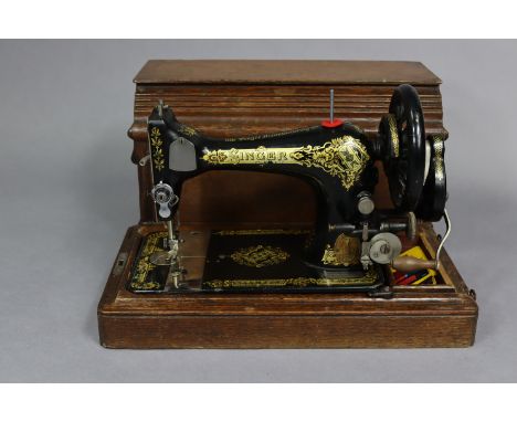 A vintage Singer hand sewing machine with oak case.