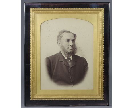 A late 19th century photographic portrait of a gentleman, displayed in ornate gilt gesso frame &amp; glazed case, with retail