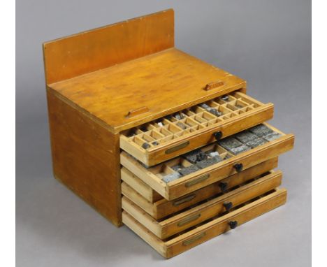 A collection of vintage typesets contained in a wooden five-drawer chest, 14¼” wide x 13¼” high.