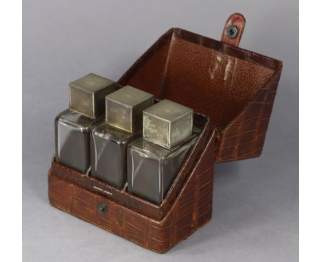 A George VI crocodile skin gent’s travelling toilet case by Asprey of London, fitted with a set of three glass receptacles, e