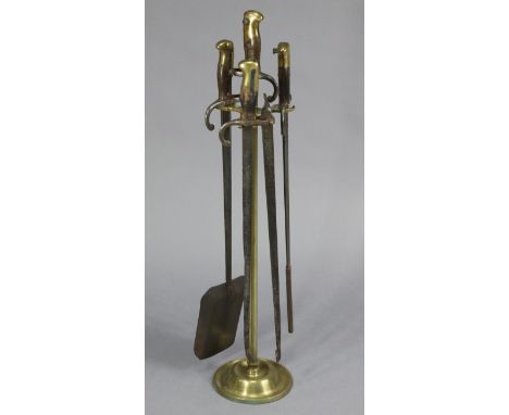 A BRASS FIRE COMPANION WITH THREE IMPLEMENTS, MADE FROM FOUR VINTAGE RIFLE BAYONETS, 31¼” HIGH.