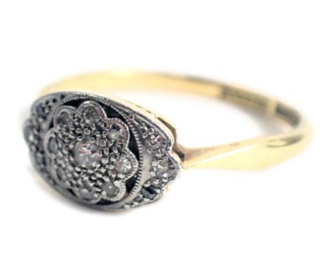 An Art Deco dress ring, the oval panel with central floral cluster, set with tiny diamonds, on a yellow metal band stamped 18