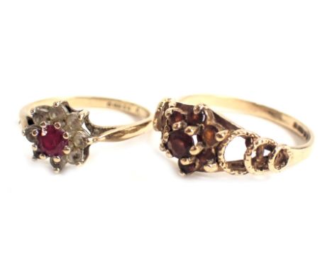 Two 9ct gold dress rings, each set with garnet, in a floral cluster, one with  CZ, ring size M and I½, 3.5g all in. (2) 