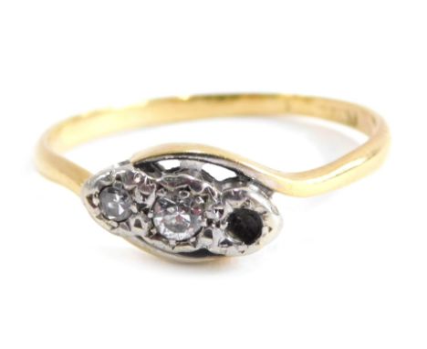 A diamond twist ring, set with two round brilliant cut diamonds, each in platinum setting, on a yellow metal band stamped 18c