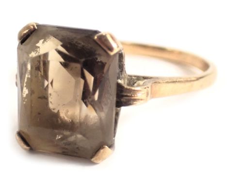 A 9ct gold dress ring, set with a rectangular cut smoky quartz, in four claw setting in a raised basket, with plain shoulders